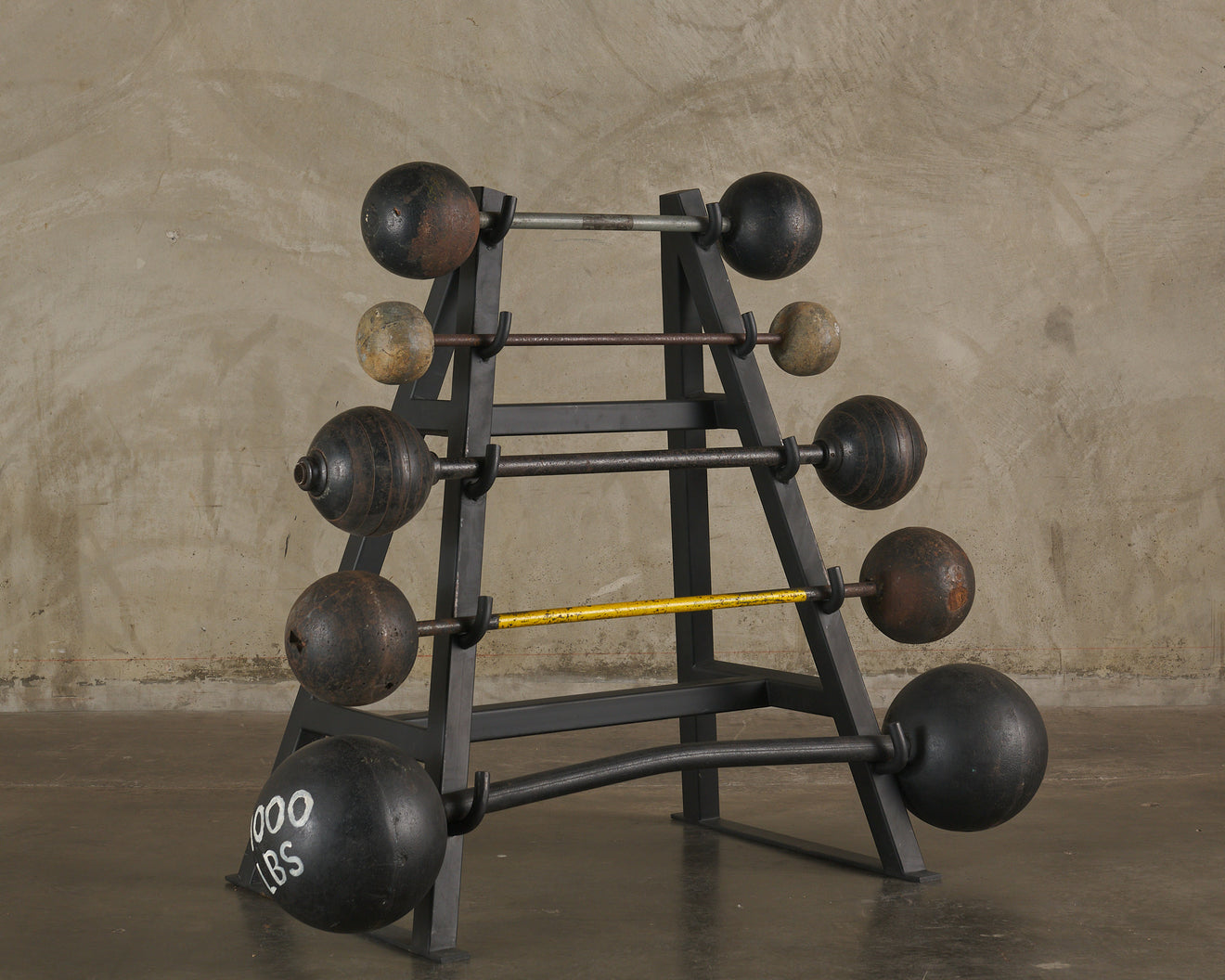 COLLECTION OF ANTIQUE BARBELLS ON STEEL MOUNT